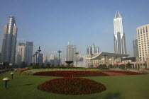 Modern city skyline seen from gardens with formal flowerbeds in the foreground