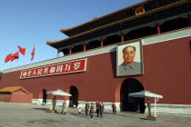 Tiananmen Monument aka Gate of Heavenly Peace with portrait of Mao on the front and two guards standing under square umbrellas