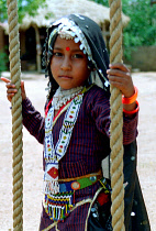 Portrait of a young girl playing on a rope swing