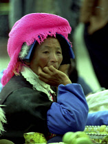 Portrait of a female street vendor wearing a pink hat