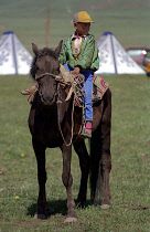 Young boy dressed as Genghis Khan riding a pony