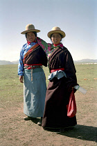 Full length portrait of two sisters travelling on foot to local festival