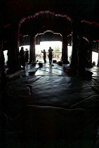 View looking out from inside the Jokhang Temple with people prostrating themselves in the entrance way