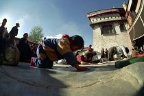 Wide angle view of  people prostrating themselves outside the Jokhang Temple