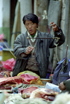 Outdoor butcher weighing Yak meat