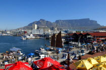 View over the waterfront area with brightly coloured umbrellas in the foreground and Table Mountain in the background