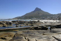 Caps Bay. View over rocky coastal area with beach and mountain beyond