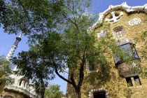 Gaudi architecture seen through trees in Parc Guell