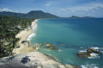 Lamai beach and coastline seen from hillside with coconut palm trees coming down to the shoreline