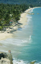 View along Lamai beach with palm trees  huts and tourists