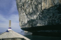 Undercut rock face seen from the bow of a long tail boat