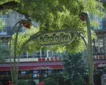 Art Nouveau `Metropolitain sign in green wrought iron under tree branches