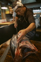 Tsukiji Fish Market with man slicing Tuna fish