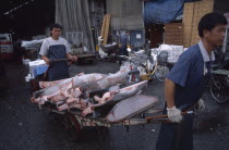 Tsukiji Fish Market with men transporting cut Tuna on a cart