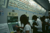 Shinjuku. People using Metro or Subway ticket vending machines