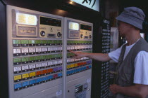 Shimbashi. Man using Restaurant Ticket vending machine