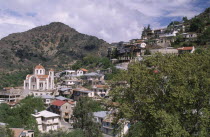 Church and houses on steep hillside.