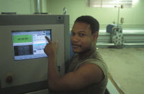 Worker setting up automatic fabric cutting machine at Pre Les bedroom textiles factory