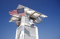 Life Guard sitting on watch tower flying the stars and stripes flag