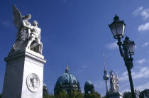 Statues and street lamps on Schlossbrucke or Castle Bridge with the dome of the Cathedral and the Alexanderplatz Television Tower in the background