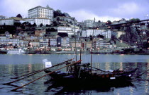 View over boats moored in the port toward the city illuminated at dusk