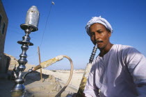 Man smoking sheesha water pipe.