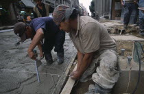 Construction workers laying concrete on building site.