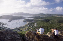 Couple sitting on rocks on hillside above Ordnance bay on the right and Tank Bay on the left.