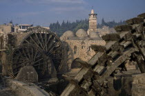 Wooden norias or waterwheels on the Orontes river and the Al-Nuri Mosque dating from 1172 and built of limestone and basalt. Section of wheel in the immediate foreground.