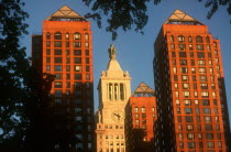 The Con Edison Building partly seen between high rise buildings.