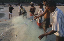 Men working on the beach sorting fishing net