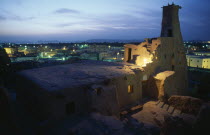 View at dusk across rooftops with old minaret in foreground