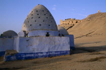 Blue painted Beehive Mausoleum with Tomb of the Nobles on hilltop behind