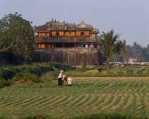 The Citadel  Ngo Mon Gate  workers tending crops in field  trees