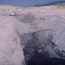 Opencast coal mine  deep quarry  loaded trucks  working crane