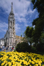 Matthias Church with flower bed full of yellow dahlias in the foreground.