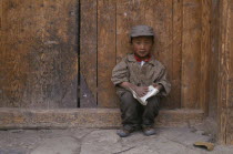 Young Tibetan boy reading a book