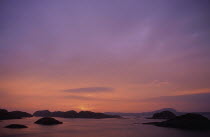 View out to sea at sunset over small islands