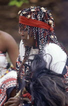 Local woman in traditional headress holding fly whisk made from wildebeast tail