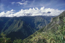 The Inca trail mountain view from Machu Pichu with clouds covering the tops of the mountains