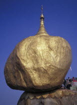 Pilgrims at the Golden Rock Pagoda a precariously perched head shaped rockBurma