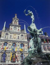 Town Hall facade decorated with flags and the Brabo Fountain in the foreground