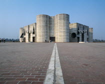 Modern stone parliament building with rounded towers.