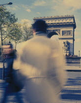 Arc de Triomphe with people  blurred in action on the street in the foreground.