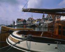 Harbour and buildings with many boats moored seen across the stern of a sailing barge