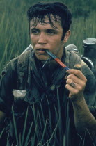 9th Division soldier near Tan An sitting in a rice paddy smoking Cambodian Red in a pipe