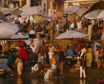 The ghats at dawn with crowds of people washing in the River Ganges.