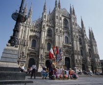 Cathedral frontage with tourists  beside a souvenir stall selling flags and scarves