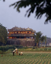 The Citadel  Ngo Mon Gate  workers tending crops in field  trees