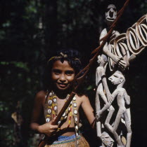 Young girl beside wooden carvings